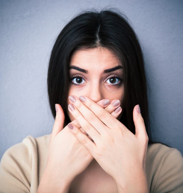 Portrait of a young woman covering her mouth a girl who has been lying to herself, you when you are lying to yourself