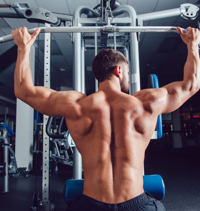 Very power athletic guy bodybuilder , execute exercise with simulator guy who is not a victim